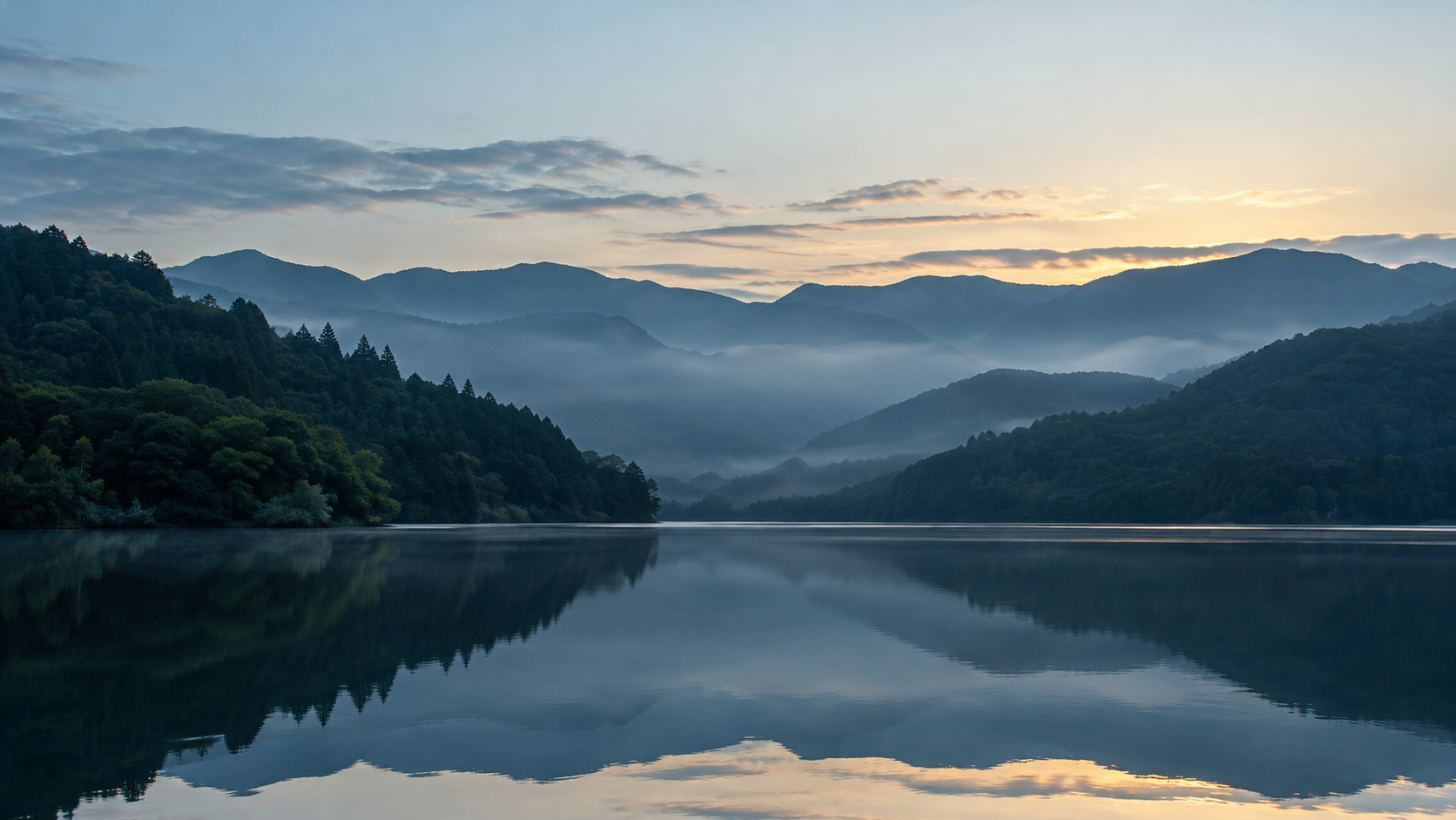 静かな湖と山々に朝の光が差すイメージ